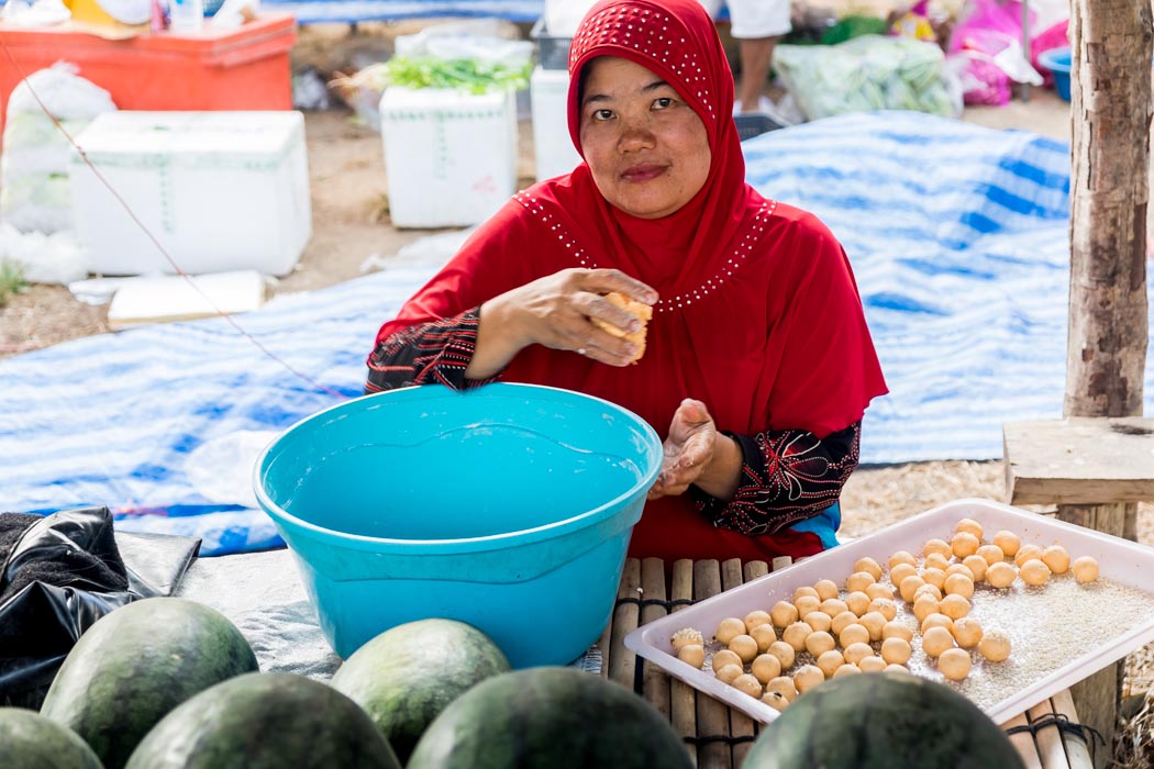 A Thai woman preparing food at the market. things to do in koh lanta